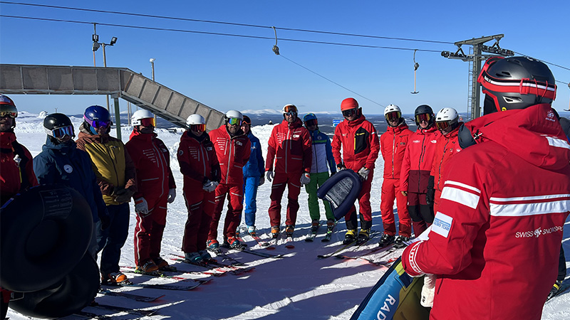 Grupp alpina skidåkare som får instruktioner i backen. Foto: Magnus Löfstrand.
